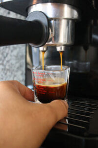 A shot of espresso being pulled on an espresso machine